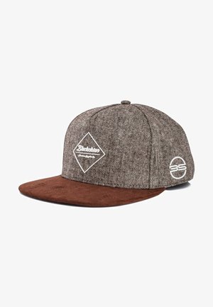 Ruda snapback skrybėlė su tekstūruotu pilku audiniu viršuje, veliūro ruda kraštine, balta logotipo detale ir geometrine etikete priekyje.