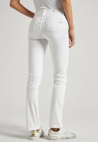 Vita, stretchy denimjeans med smal passform, fem fickor och mid-rise midja, med en subtil sömnadsdetalj på bakfickorna.