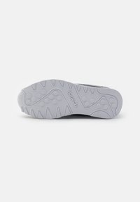 Reebok Sneaker-Sohle, Gummi-Material, hellgrau, strukturierte Oberfläche mit kreisförmigen und gewellten Mustern, mit auffälligen Traktionsrillen.