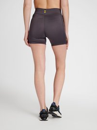 Höga, mörkgrå träningsshorts med en mjuk yta, med gula detaljer och en åtsittande passform, kombinerat med svarta löparskor.