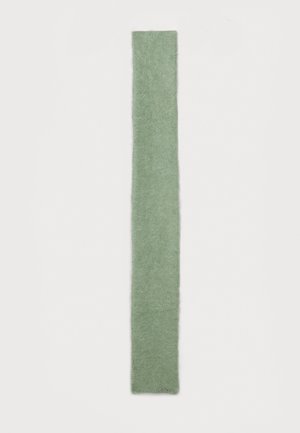 Écharpe rectangulaire en laine verte avec une texture douce, présentant un léger éclat et des variations subtiles de teinte. Logo brodé à une extrémité.