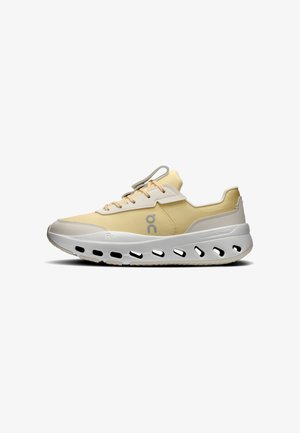 Chaussure de sport jaune et beige avec semelle blanche présentant plusieurs découpes ovales et des lacets beiges, vue de profil sur fond blanc.