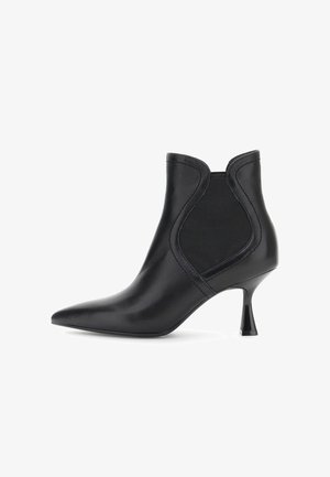 Stivaletto in pelle nera con punta affusolata, pannelli laterali elastici e sottile tacco curvo di altezza media su sfondo bianco.