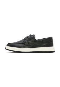Scarpa slip-on in pelle nera con superficie testurizzata, dotata di suola in gomma bianca e dettagli di cucitura sottili per un tocco aggiuntivo.