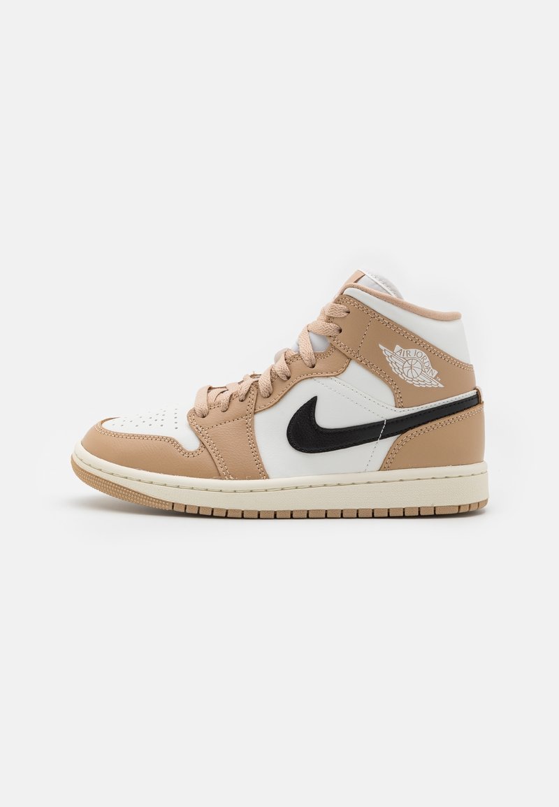 Basket montante Air Jordan blanche et beige avec un swoosh Nike noir et des lacets beiges sur un fond uni.