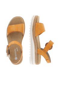 Sandales en cuir orange avec deux larges sangles, semelle texturée et décorations au niveau de la cheville. Semelle intérieure rembourrée pour le confort.