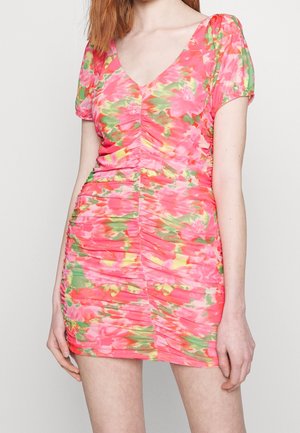 Mini-jurk met plooien in roze stof met een groen en geel bloemenpatroon, voorzien van korte pofmouwen en een diepe V-halslijn. Soepele textuur.