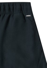 Jupe noire à taille élastique avec des rayures verticales subtiles et une petite étiquette métallique de la marque près de la poche côté droit.