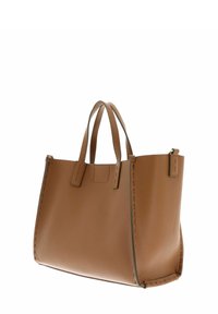 Sac fourre-tout en cuir fauve avec une finition texturée, deux poignées supérieures et un design minimaliste. Présente des coutures visibles et un dessus ouvert.