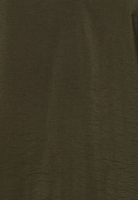 Tissu vert olive uni avec de légères rides texturées, sans motifs ni autres objets visibles.