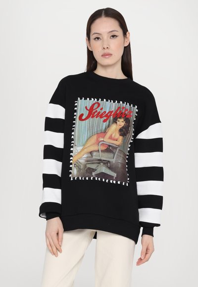 Black sweatshirt with a vintage-style graphic featuring a seated figure. Striped white and black sleeves, ribbed cuffs, and hem.
