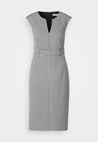 Robe à motif pied-de-poule noir et blanc avec un décolleté en V, des manches courtes, une taille ajustée, et une fermeture éclair discrète au dos. Texture de tissu lisse.