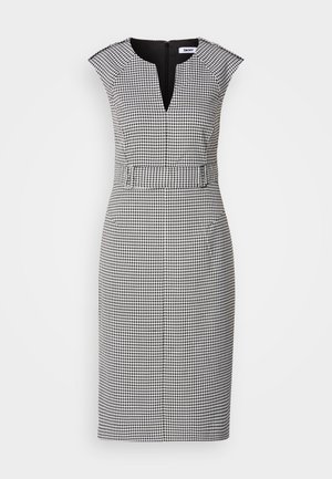 Juoda ir balta šunų dantų rašto suknelė su V formos dekoltė, trumpomis rankovėmis, prigludusia juosmens dalimi ir diskretišku užtrauktuku nugaroje. Lygus audinio paviršius.