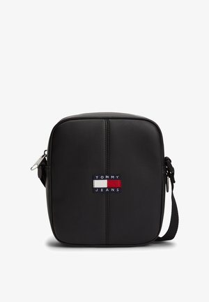 Sort crossbodytas i syntetisk læder med firkantet form, der har et frontlogo i blå, hvid og rød. Justerbar rem inkluderet.