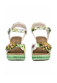 Sandales compensées à motif floral avec semelles tressées vertes, brides à la cheville et ornements de fleurs jaunes sur les brides des orteils.