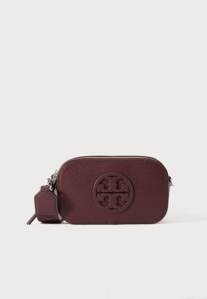 Tamno burgundski strukturirani kožni crossbody torba u obliku zaobljenog pravokutnika s utisnutim kružnim logotipom sprijeda.