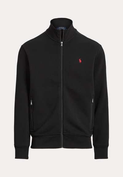 Veste noire zippée avec col montant, deux poches zippées à l'avant et petit logo rouge Polo Ralph Lauren sur la poitrine gauche.