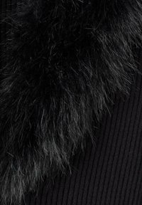 Tessuto a coste nero con un evidente accento di pelliccia sintetica nera, caratterizzato da lunghe fibrose morbide e una texture lucida lungo il bordo.