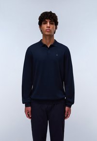 Polo a maniche lunghe blu navy in cotone; presenta un colletto, una chiusura a tre bottoni e polsini a coste. Dettaglio del logo frontale.