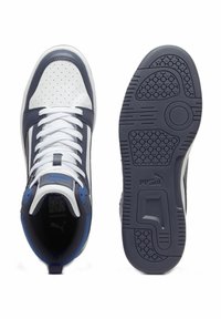 Zapatillas deportivas en azul marino y blanco con cuero perforado, cordones planos, cuello acolchado y suela texturizada con un logotipo en el talón.