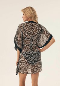 Przezroczysty kimono z czarno-beżowym wzorem zebry, z luźnymi rękawami, wiązaniem w talii i lekko przezroczystą teksturą.