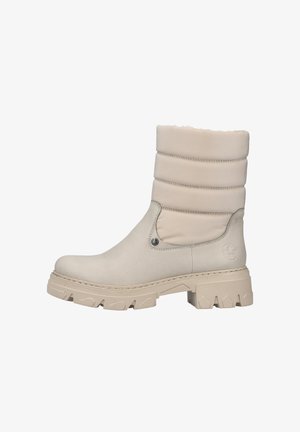 Beige waterdichte boot met een gevoerde schacht, gestructureerd exterieur en een stevige rubberen zool. Bevat een decoratieve metalen accent nabij de enkel.