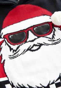 Zwart en rood gebreid sweater met een ontwerp van het gezicht van de kerstman, voorzien van zwarte zonnebril, witte baard en een pomponaccent bovenop de capuchon.