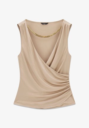 Haut beige sans manches de style portefeuille avec un décolleté en V plongeant et un détail de chaîne dorée attachée au col.
