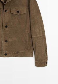 Bruine suède jas met borstzak met klep en knoop, zijzak met split, zwarte knopen aan de voorkant en op de manchet, zichtbare stikseldetails.