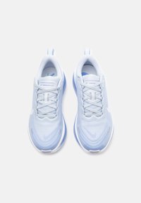 Světle modré běžecké boty s prodyšným svrškem, polstrovanými jazyky, plochými tkaničkami a měkkou texturovanou podrážkou. Logo Nike viditelné po stranách.