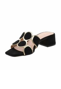 Scarpa scivolata in suede nero con dettagli in oro e un design floreale caratterizzato da ampi fori circolari. Punta quadrata e tacco basso a blocco.