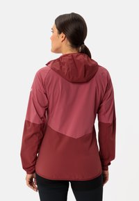 Lightweight jacket in burgundy, featuring a hood, contrasting panels, and long sleeves. Smooth texture with a sporty design.