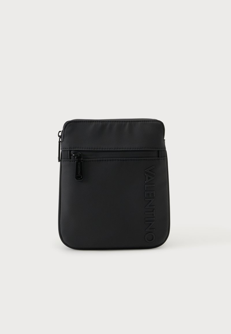 Μαύρη ορθογώνια τσάντα crossbody με μπροστινή τσέπη με φερμουάρ και ανάγλυφο λογότυπο Valentino σε μονόχρωμο φόντο.