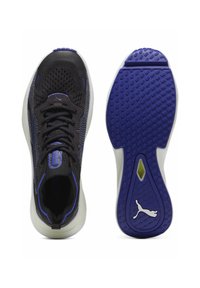 Fekete sportcipők hálós felsőrésszel, lila részletekkel, textúrált talppal, kerek orral és integrált fűzőrendszerrel. Kiemelkedő logóval rendelkezik.