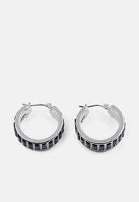 Sølvtone hoop øreringer med en sort teksturert bånd og vertikal utskjæringsmønster. Sirkulært design med en sikker lås.