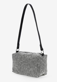 Bolso rectangular con una correa de cuero negro, cubierto de, brillantes plateados dispuestos en un patrón de cuadrícula. Textura suave, diseño moderno.