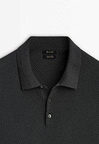 Polo noir en tricot texturé avec un col côtelé et une patte de boutonnage à deux boutons, étiqueté "Massimo Dutti" et "Coton extra fin."