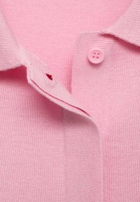 Růžový žebrovaný polo tričko s knoflíkovou légou a kulatým růžovým knoflíkem, vyrobené z měkkého materiálu.