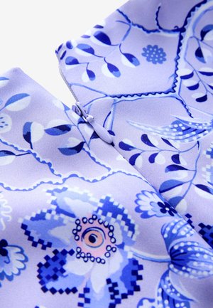 Jasnofioletowa tkanina z misternymi niebieskimi wzorami kwiatowymi i liśćmi. Widoczny szczegół zamka błyskawicznego podkreśla wzór. Miękka tekstura.