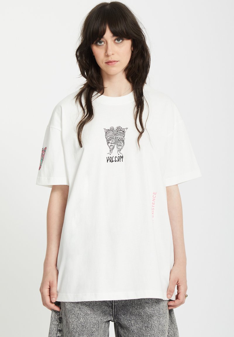 T-shirt bianca in cotone a maniche corte, con un design grafico nero sul petto e dettagli colorati sulla manica sinistra.