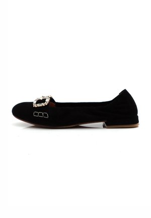 Black suede flat shoe featuring a square gem-encrusted buckle and subtle stitched detailing, with a low heel for comfort.