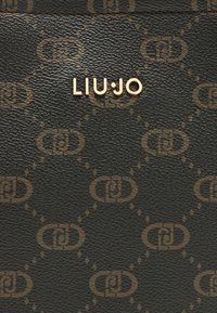 Schwarze, strukturierte Geldbörse mit einem sich wiederholenden braunen Muster und dem goldenen "LIU•JO" Schriftzug in moderner Schriftart.