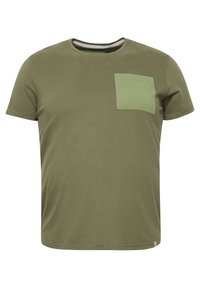 Oliven grøn t-shirt med korte ærmer, rund hals og en kontrastfarvet grøn lomme på venstre bryst. Blødt, struktureret bomuldsstof.