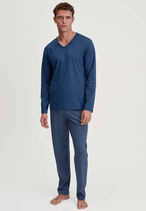 Marineblauw shirt met lange mouwen en V-hals, gecombineerd met gestreepte pyjamabroek met een geometrisch ontwerp in lichtere blauwtinten.