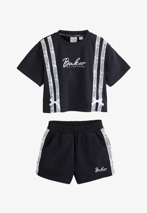 Sort todelt sæt med korte ærmer og shorts, med hvide blonderstriber og "Baker by Ted Baker" tekst på top og shorts.