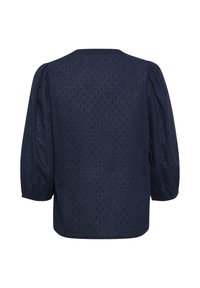 Blusa blu navy con un motivo a pois testurizzati, maniche lunghe a sbuffo e taglio dritto. Presenta un semplice scollo rotondo e una finitura liscia.