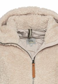 Cremefarbener Fleece-Jacke mit Reißverschluss, strukturiertem Äußeren, gefütterter Kapuze und einem Logotag innen. Verfügt über ein braunes Leder-Detail am Reißverschluss.