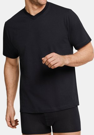 Man wearing plain black V-neck short-sleeve T-shirt and black boxer briefs against a white background.