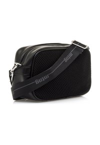 Pequeña bolsa cruzada negra con panel frontal de malla, correa ajustable negra con marca gris, y herrajes de cremallera y clip en plata.