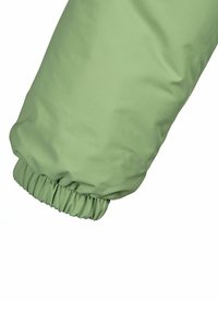 Grön, elastisk manschett av ett lätt, texturerat ärm, tillverkad av ett slätt, vattenavvisande material, som framhäver dess rundade form.